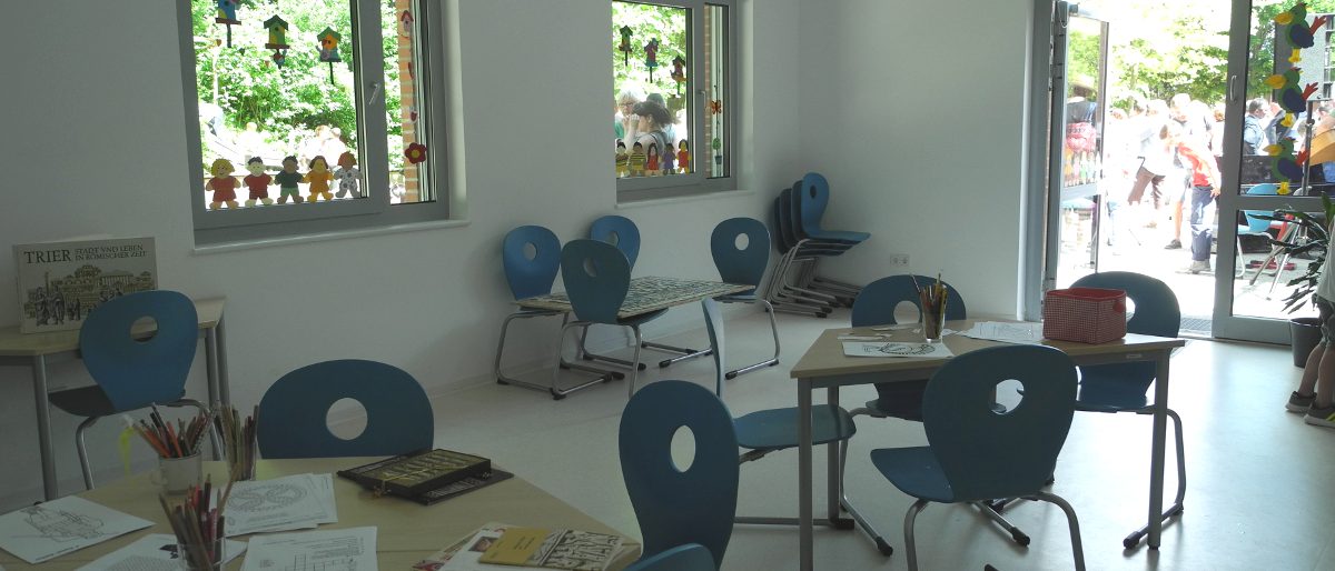Innenansicht Klassenraum mit blauen Stühlen und Tischen